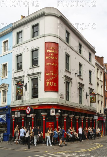 People sitting outside The Coach and Horses pub, Romilly Street, Soho, London, England, UK