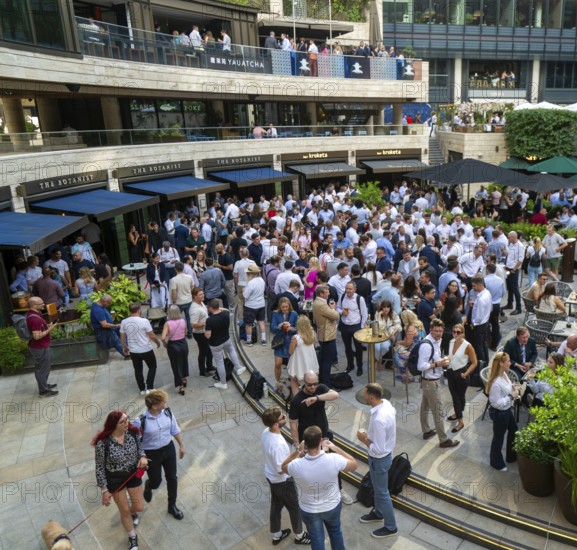 Crowd of people after work drinks outside The Botanist restaurant bar, Broadgate Circus, City of London, England, UK