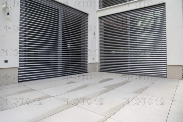 Modern terrace with large, light-coloured terrace tiles on a new detached house