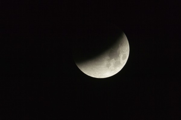 On 28.09.2015, 03:41 am... partial lunar eclipse, full moon dips into the earth's shadow, appears as a crescent moon lying on its back, night-black sky, dark night, super telephoto, super moon, local nature, Meerbusch, DÃ¼sseldorf, Rhineland, Lower Rhine, North Rhine-Westphalia, Germany, Western Europe