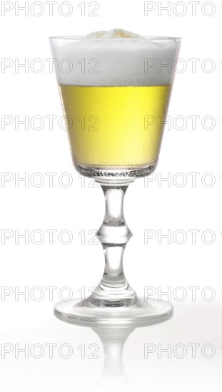 Cocktail with head of foam in a pointed goblet style glass in front of a white background, studio shot