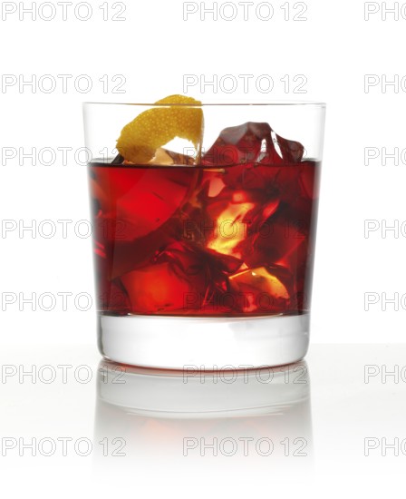 Cocktail in a tumbler on ice with an orange zest as garnish against a white background, studio shot