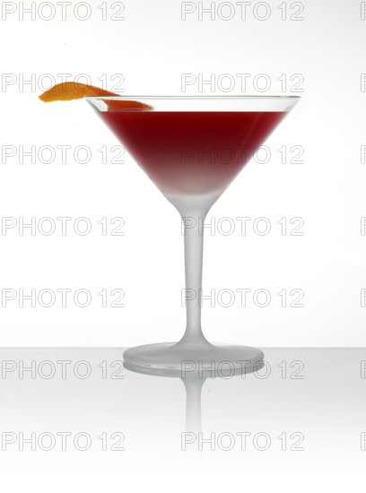 Cocktail in a cocktail glass with orange zest as garnish in front of a white background, studio shot