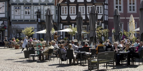 People in the outdoor catering area in the old town with many half-timbered houses, GroÃŸer Plan, Celle, Lower Saxony, Germany