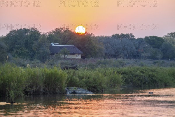 Red glowing sun, sunset at the Sabie River near Skukuza Camp, Kruger National Park, South Africa