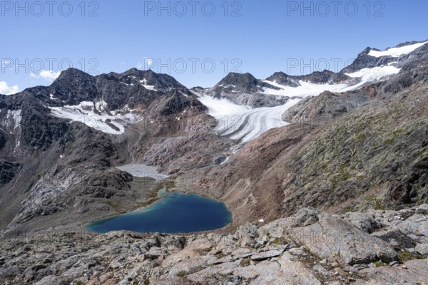 Blue glacial lake in a rocky mountain landscape, behind Königshofspitz and Ãœbeltalferner glacier, descent from the summit of Roter Grat, Stubai Alps, South Tyrol, Italy