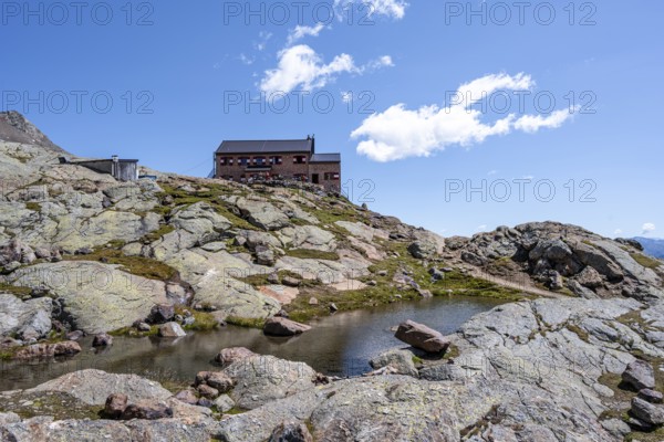 TeplitzerhÃ¼tte mountain hut and small mountain lake, Stubai Alps, South Tyrol, Italy