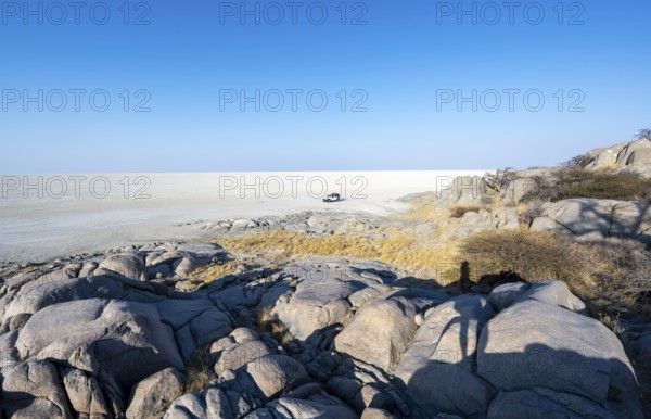 Round rocks of Kubu Island with view over the salt pan, off-road vehicle on the salt pan, Kubu Island (Lekubu), Sowa Pan, Makgadikgadi Salt Pans, Botswana
