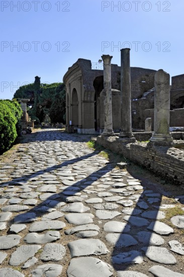 Ancient pavement of the main street Decumano Massimo, Roman theatre, columns, remains, ruins, ancient port city of Rome, excavation site Archaeological Park Ostia Antica, metropolitan city of Rome, Lazio, Italy