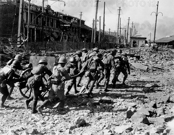 Photograph of a group of soldiers walking through destroyed Shanghai during the Second Sino-Japanese War from 1937 to 1945. Battle of Shanghai.1937