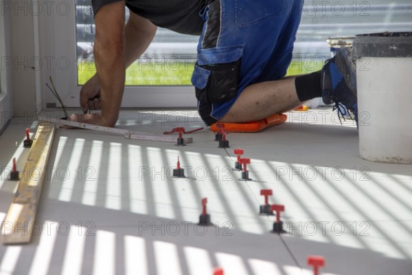 Tiler lays new floor tiles