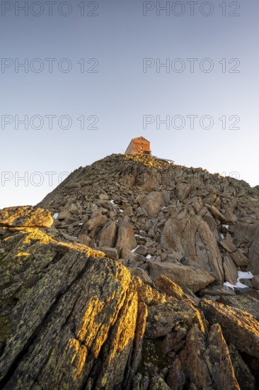 Stony summit of the Becher with mountain hut Becherhaus in the morning light at sunrise, Stubai Alps, South Tyrol, Italy