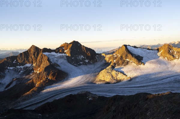 Picturesque high mountain landscape at sunrise with alpenglow, glacier and rocky mountain peaks in the morning light, view of the Königshofspitz mountain peak and Ãœbeltalferner glacier, Stubai Alps, South Tyrol, Italy