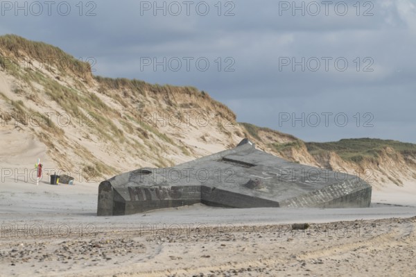 Abandoned bunker from the 2nd World War, sunken into the sand with graffiti, surrounded by sand dunes, beach near Hvide Sande, North Sea, Denmark