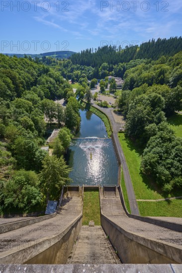 A high view of a dam with a river and lots of greenery all around under a clear sky, Oleftalsperre, Hellenthal, Eifel, North Rhine-Westphalia, Germany
