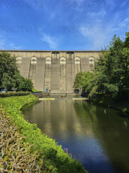 Dam wall with river in the foreground, surrounded by trees and reflected in the water, Oleftalsperre, Hellenthal, Eifel, North Rhine-Westphalia, Germany