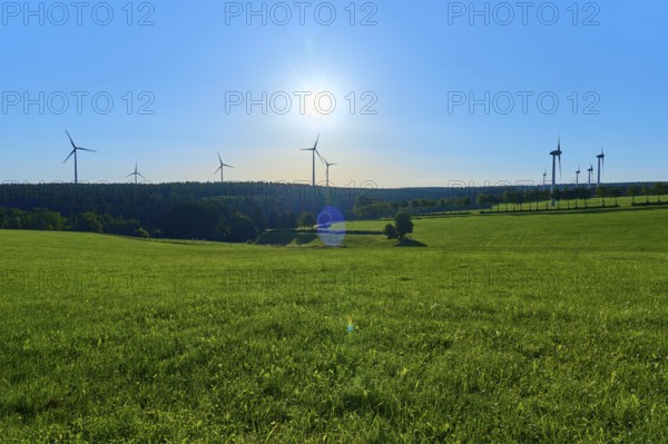 Wind turbines towering on a green meadow under a bright sky, summer, Rohren, Monschau, Eifel, North Rhine-Westphalia, Germany