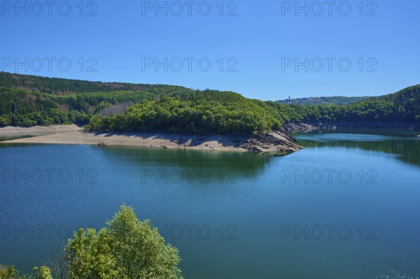 View of a lake with wooded shores and hills under a clear blue sky, summer, Urft dam wall, Obersee, Urftsee, Schleiden, Eifel National Park, Eifel, North Rhine-Westphalia, Germany
