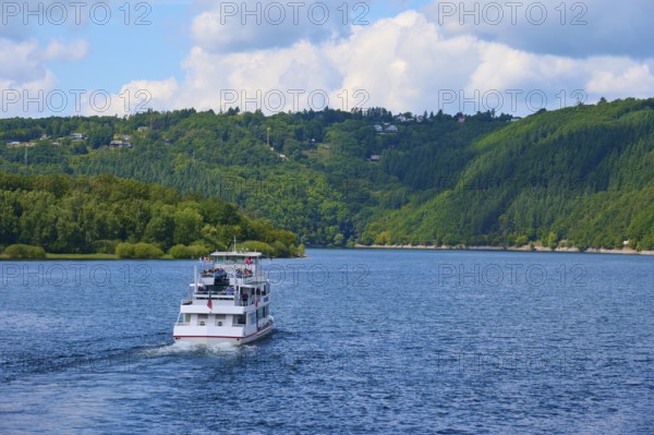 A passenger ship, stern view, sailing across a wide lake, surrounded by green hills, summer, Rursee, Rurtalsperre, Heimbach, Simmerath, Eifel National Park, North Rhine-Westphalia, Germany