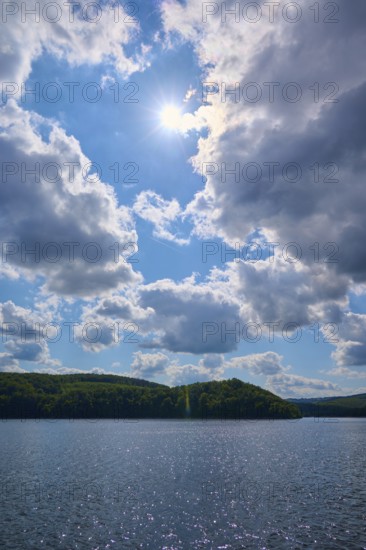 A sunny sky over a calm lake with scattered clouds and green hills, summer, Rursee, Rurtalsperre, Simmerath, Eifel National Park, North Rhine-Westphalia, Germany