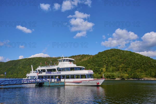 Passenger ship at the jetty, surrounded by green hills and blue sky, summer, Rursee, Rurberg, Simmerath, Eifel National Park, North Rhine-Westphalia, Germany