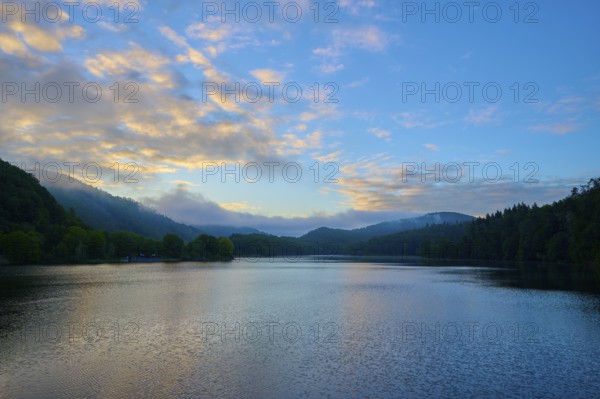 Gentle morning colour reflected on the quiet lake, surrounded by hills and clouds, summer, Rursee, Obersee, Rurberg, Simmerath, Eifel National Park, North Rhine-Westphalia, Germany