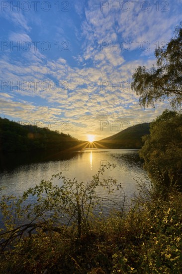 Sunset over a lake, dramatic cloud formations and golden light on the water, summer, Rursee, Obersee, Simmerath, Eifel National Park, North Rhine-Westphalia, Germany