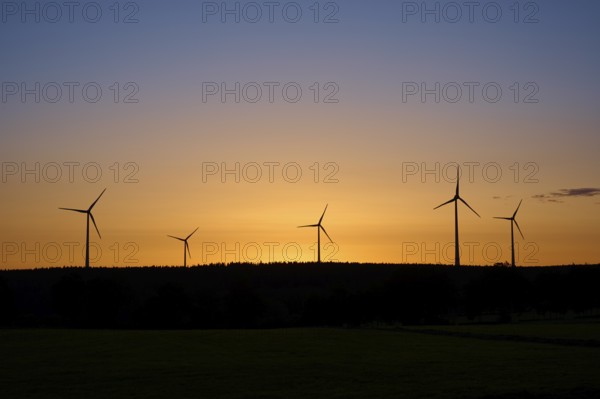 Wind turbines in front of an orange-coloured sunrise, Rohren, Monschau, Eifel, North Rhine-Westphalia, Germany
