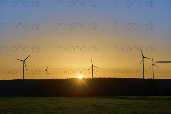 Sunrise, behind a row of wind turbines, bathing the landscape in warm light, summer, Rohren, Monschau, Eifel, North Rhine-Westphalia, Germany