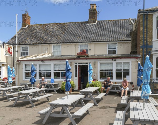 People sitting outside the Red Lion pub, Southwold, Suffolk, England, UK