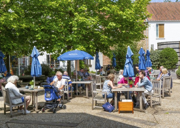 People sitting outside at the cafe, Adnams brewery shop, Southwold, Suffolk, England, UK