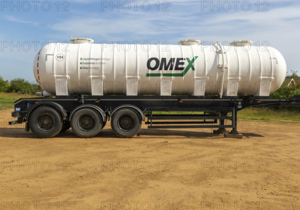 Omex fertiliser road tanker container waggon standing in field, Alderton, Suffolk, England, UK