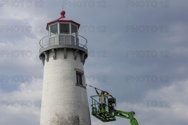 Detroit, Michigan - A worker on a lift paints the Milliken State Park Lighthouse. The lighthouse is on the Detroit River, near downtown Detroit