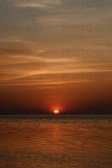 Fireball... Sunset over the Wadden Sea near Duhnen, Cuxhaven, North Sea, glowing red setting sun, sun sinks into the sea, a beautiful day comes to an end, North Sea coast, atmospheric picture, local nature, Lower Saxon Wadden Sea National Park, North Sea near Cuxhaven, Duhnen, Lower Saxony, Germany, Western Europe