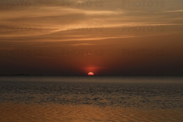 Atmospheric sunset... Cuxhaven, North Sea, in calm weather, glowing red sun sinking into the sea, calm sea, great light, absolute silence, Wadden Sea off Lower Saxony, atmospheric picture, local nature, Lower Saxony Wadden Sea National Park, North Sea near Cuxhaven, Duhnen, Lower Saxony, Germany, Western Europe