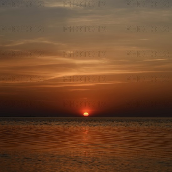 Fireball... Sunset over the Wadden Sea near Duhnen, Cuxhaven, North Sea, glowing red setting sun, sun sinks into the sea, a beautiful day comes to an end, North Sea coast, atmospheric picture, local nature, Lower Saxon Wadden Sea National Park, North Sea near Cuxhaven, Duhnen, Lower Saxony, Germany, Western Europe