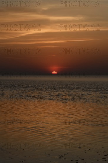 Atmospheric sunset... Cuxhaven, North Sea, in calm weather, glowing red sun sinking into the sea, calm sea, great light, absolute silence, Wadden Sea off Lower Saxony, atmospheric picture, local nature, Lower Saxony Wadden Sea National Park, North Sea near Cuxhaven, Duhnen, Lower Saxony, Germany, Western Europe