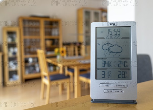 Summer heat, digital thermometer in an attic flat, city centre, outside temperature in the afternoon over 34Â°C, in the flat 31Â°C, flat without air conditioning, heats up a lot, health risk, symbolic image climate change