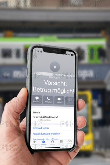 Symbolic image of mobile phone scam, warning of fraudulent calls, here the provider Vodafone, warns the mobile phone user that the caller may have a suspicious number that suggests fraud, spam protection system, the caller's number is stored in a database in which suspicious spam callers are stored, prevention of fraud attempts via mobile phone