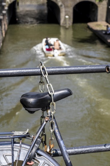 Cycling in the Netherlands, Utrecht, bicycle secured with a chain of steel links on a bridge over a canal, Netherlands