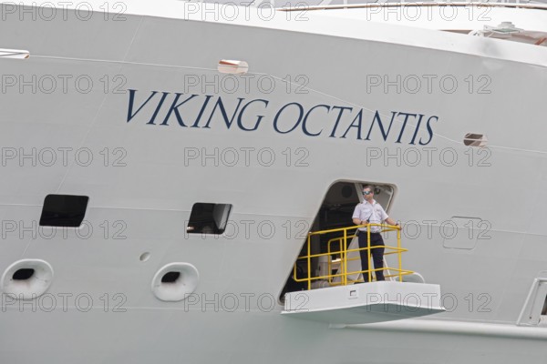 Detroit, Michigan - The Viking Octantis luxury cruise ship in Detroit on a cruise through the Great Lakes. A crew member keeps watch as the ship prepares to leave the dock