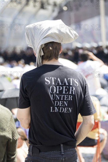 A visitor protects himself from the sun with fabric on his head at the Staatsoper fÃ¼r alle, a free open-air concert with conductor Christian Thielemann and the Staatskapelle Berlin on Berlin's Bebelplatz, Berlin, 22 June 2025