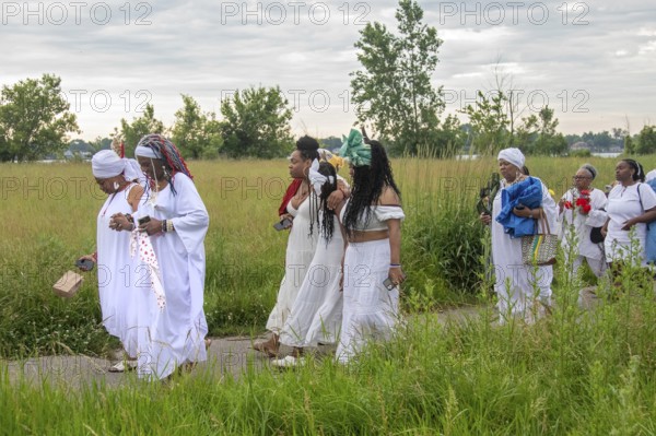 Detroit, Michigan - African-Americans gather on the banks of the Detroit River to commemorate ancestors lost in the slave trade. The annual event, known as The Carnival of the Spirit, is organized by the African Diaspora Ancestral Commemoration Institute
