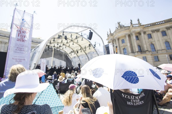 Audience with sun protection at the Staatsoper fÃ¼r alle, a free open-air concert with conductor Christian Thielemann and the Staatskapelle Berlin on Berlin's Bebelplatz, Berlin, 22 June 2025