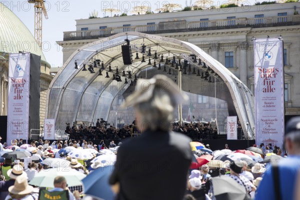 A visitor protects himself from the sun with a newspaper on his head at the Staatsoper fÃ¼r alle, a free open-air concert with conductor Christian Thielemann and the Staatskapelle Berlin on Berlin's Bebelplatz, Berlin, 22 June 2025