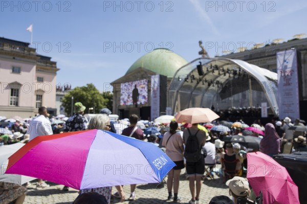 Visitors with parasols at the Staatsoper fÃ¼r alle, a free open-air concert with conductor Christian Thielemann and the Staatskapelle Berlin on Berlin's Bebelplatz, Berlin, 22 June 2025