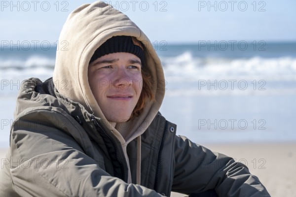 Young man with red hair, sitting on the beach, Jeffreys Bay near Port Elizabeth, Garden Route, Eastern Cape, South Africa