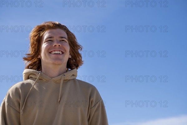 Young man red-haired, laughing, against blue sky, Jeffreys Bay near Port Elizabeth, Garden Route, Eastern Cape, South Africa