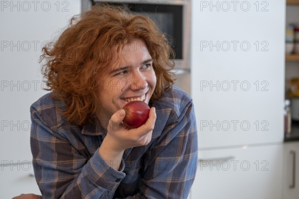 Young man, with apple, eating fruit, Kitchen Food, Bavaria, Germany