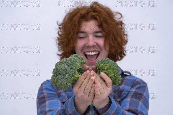 Young man, happy about broccoli, vegetables, kitchen food, Bavaria, Germany